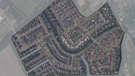 Schepenwijk in Medemblik vanuit de lucht, waarbij de contouren van de wijk duidelijk zichtbaar zijn, gezien alsof je hoog boven de omgeving vliegt.