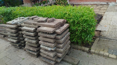 Stapels tuintegels voor een heg